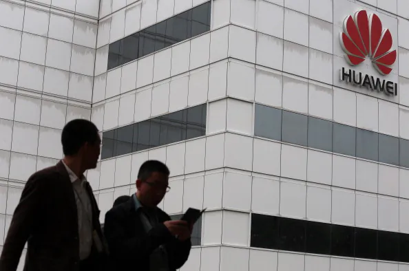 People walk by a building on the Huawei campus in the Chinese city of Shenzhen on April 7, 2013. (Aaron Tam/AFP/Getty Images)