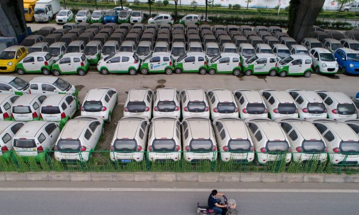 A motorist rides past new electric vehicles in Wuhan, Hubei Province, on May 22, 2017.  (STR/AFP/Getty Images)