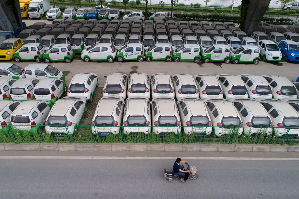 A motorist rides past new electric vehicles in Wuhan, Hubei Province, on May 22, 2017.  (STR/AFP/Getty Images)