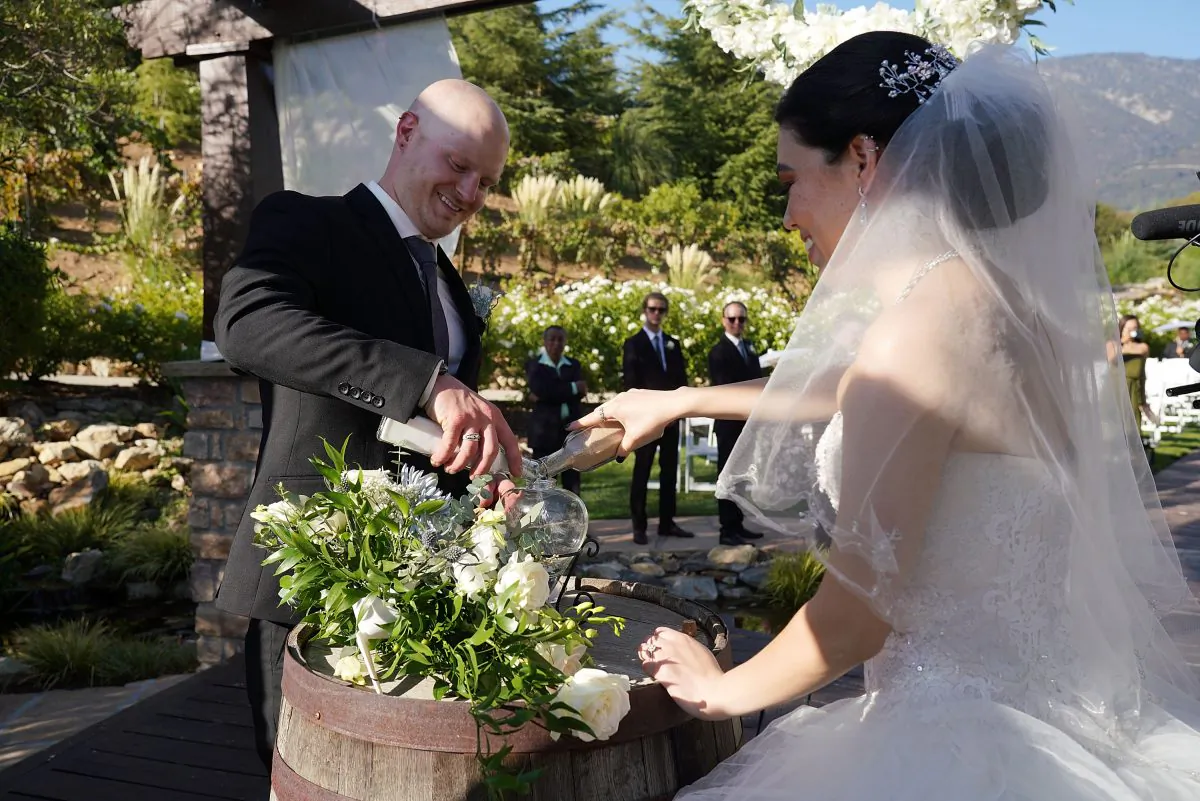 Stefany Ornelas and Alex Washer perform the unity sand ceremony during their wedding ceremony at Serendipity Garden in San Bernardino, California on Sept. 7, 2018. (JC Olivera/Getty Images for Stellar)