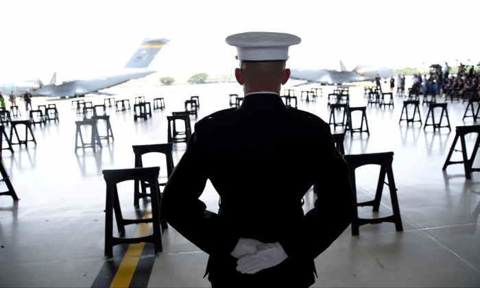 A U.S. Marine stands as caskets in a file photo. (Reuters/Hugh Gentry/File Photo)