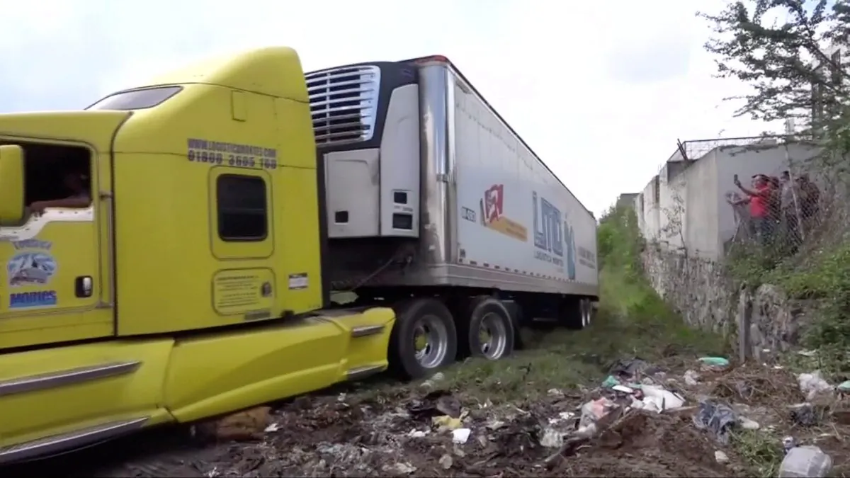 A truck leaves with an abandoned trailer full of bodies that has been parked in Tlajomulco de Zuniga, Jalisco, Mexico September 15, 2018 in this still image taken from a video obtained September 17, 2018. (By Reuters TV/Reuters)