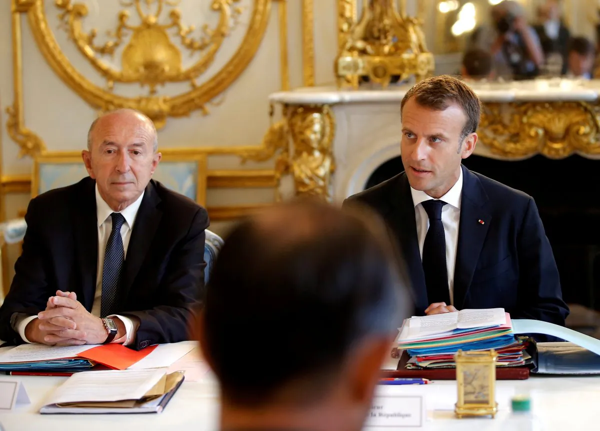 French President Emmanuel Macron sits next to Interior Minister Gerard Collomb at the Elysee Palace in Paris, France on Aug. 3, 2018. (Michel Euler/Pool via Reuters/File Photo)
