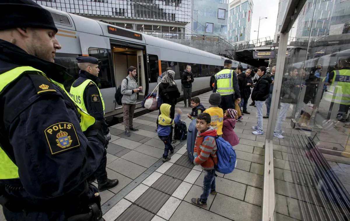 Policemen and a group of migrants stand on the platform at the Swedish end of the bridge between Sweden and Denmark in Malmo, Sweden, on Nov. 12, 2015. (Stig-Ake Jonsson/AFP/Getty Images)