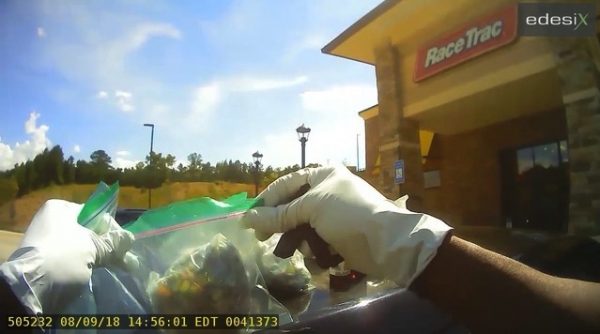A police officer holds up drugs that look like candy