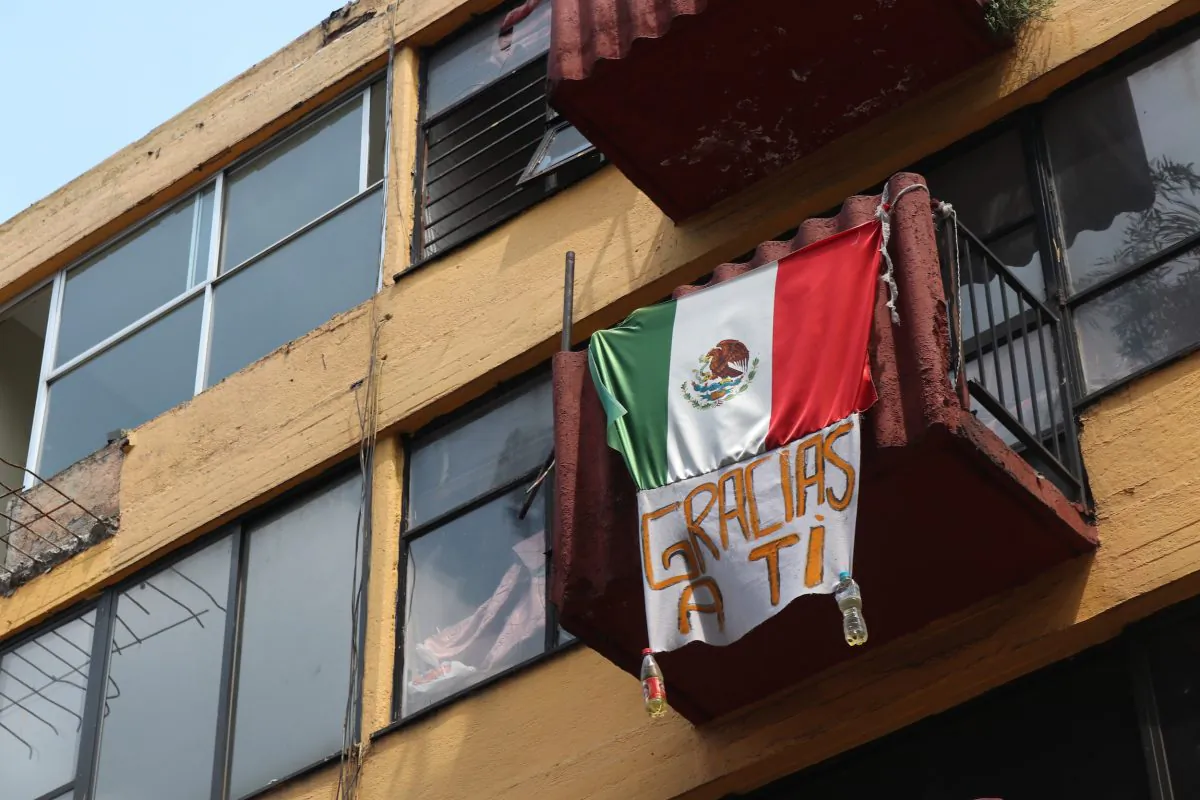 A Mexican flag with a sign that says “thanks to you” on Sept. 19, 2018 on a building in Multifamiliar Tlalpan, a housing development south of Mexico City, which sustained a lot of damage during the 2017 Mexico earthquake. (Tim MacFarlan/Special to The Epoch Times)