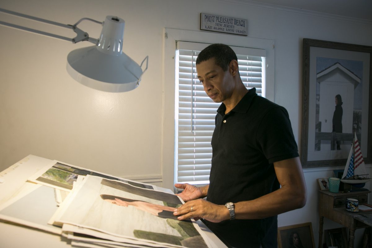 Artist, Mario A. Robinson looks at his paintings in his studio at home in Point Pleasant, New Jersey on September 4, 2018. (Milene Fernandez/The Epoch Times)