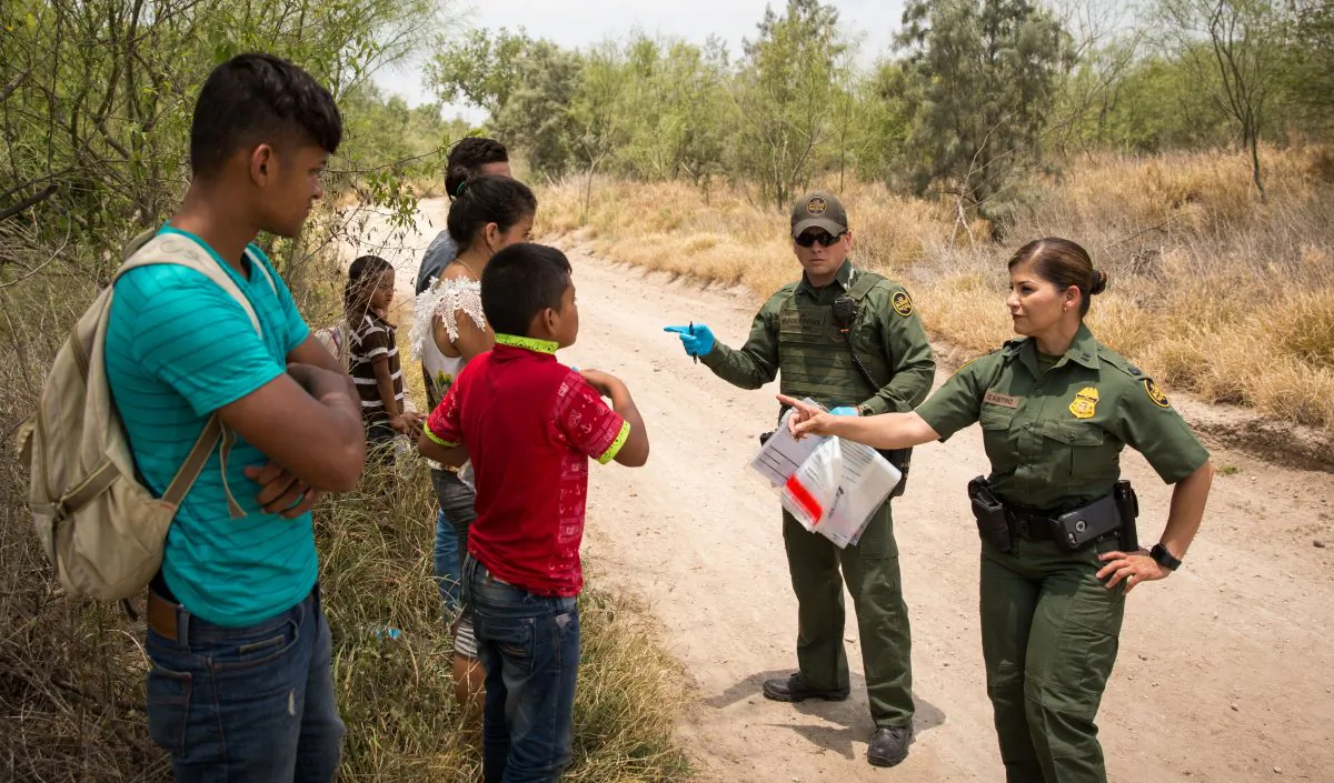Border Patrol agents have aliens remove their shoelaces and belongings before loading them in a van for transport in Hidalgo County, Texas, on May 26, 2017. (Benjamin Chasteen/The Epoch Times)