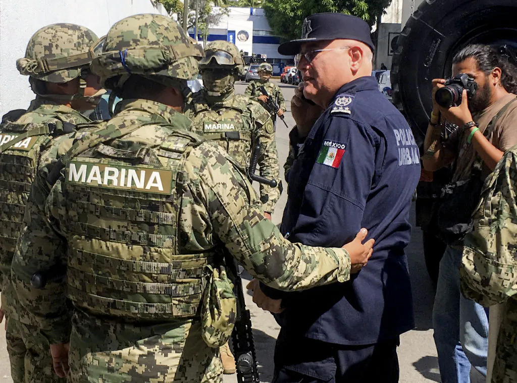 Mexican Navy members escort the Secretary of Public Security of Acapulco Max Lorenzo Sedano (R) after they took control of the local Public Security Secretariat in Acapulco, Mexico, on Sept. 25, 2018. Mexican military forces arrested at least two police officers in Acapulco and took control of the local Public Security Secretariat due to possible links to organized crime. (Francisco Robles/AFP/Getty Images)
