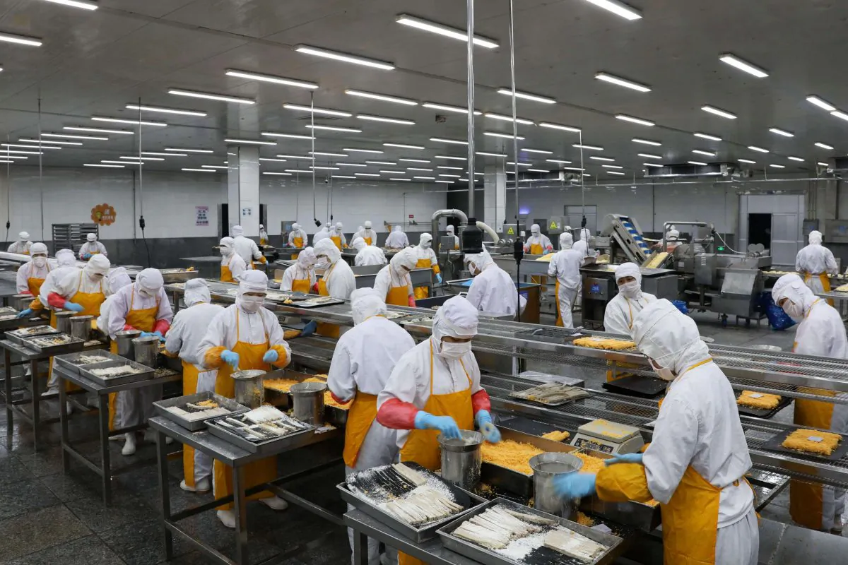 Workers process pork at a food factory in Rongcheng in Shandong Province, on July 19, 2018. (AFP/Getty Images)
