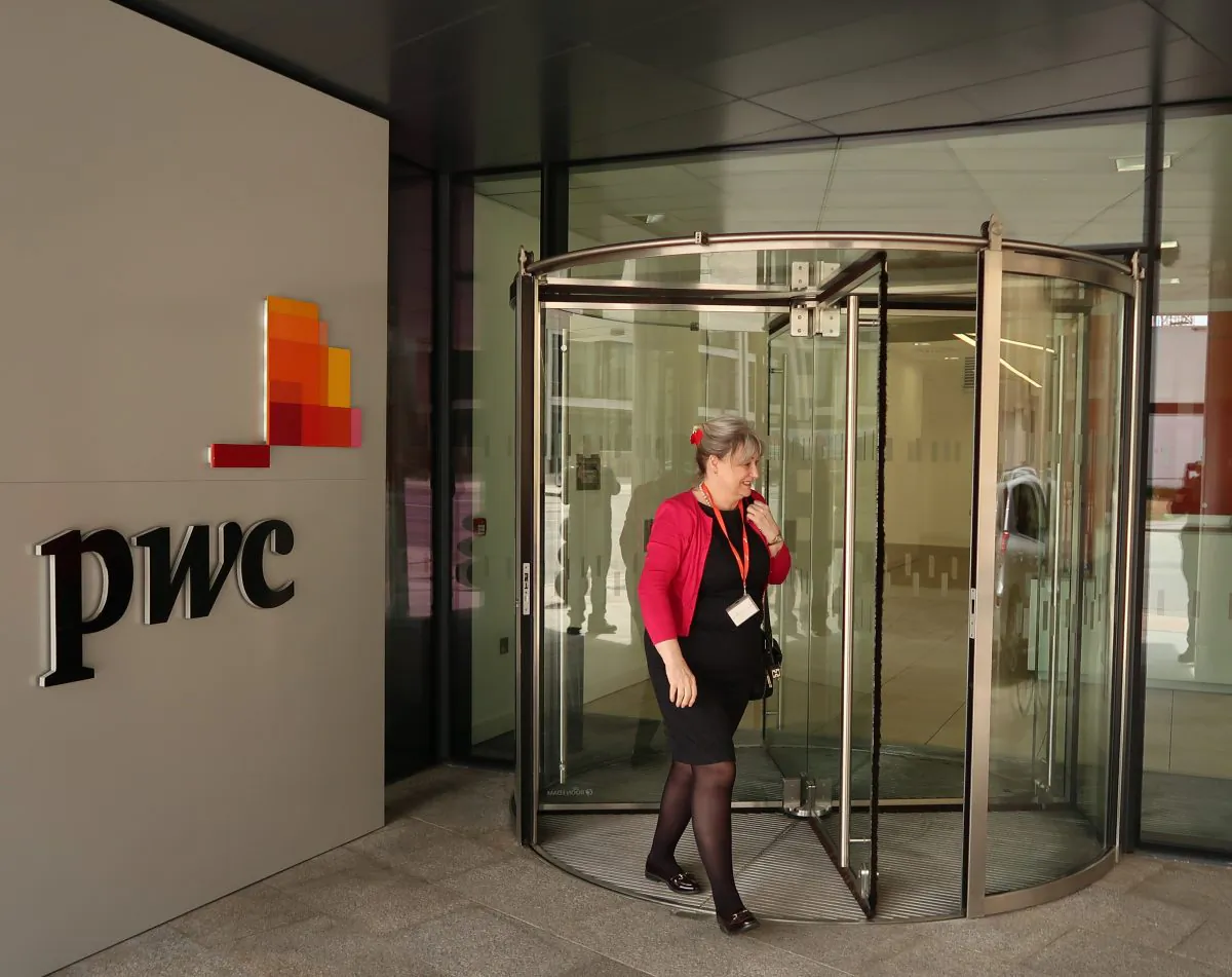 People pass the offices of PricewaterhouseCoopers (PwC) in St Helier, Jersey, on April 12, 2017. (Matt Cardy/Getty Images)