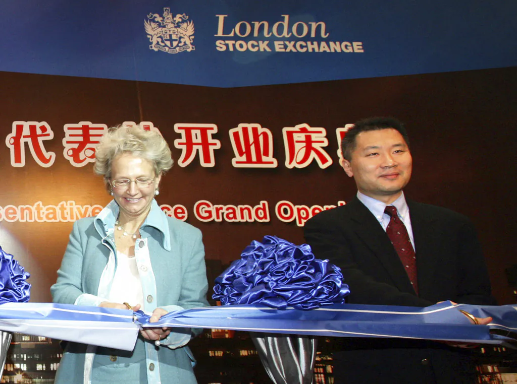 Former Chinese securities regulator Yao Gang (right) and Clara Furse, the then-Chief Executive of the London Stock Exchange, participate in a ribbon-cutting event at a business center for the LSE in Beijing on Jan. 18, 2008 (Chinatopix via AP)
