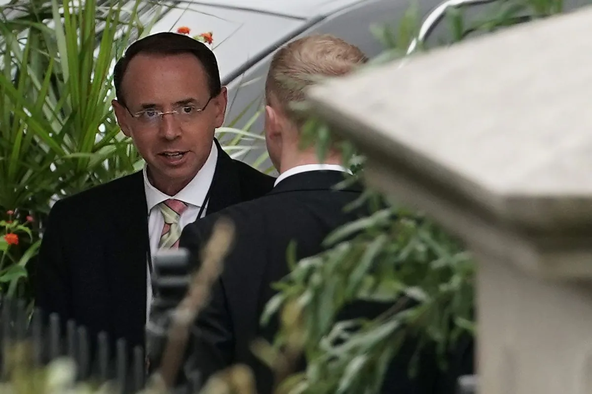 Deputy Attorney General Rod Rosenstein talks to an unidentified man as he arrives at the White House in Sept. 27, 2018. (Alex Wong/Getty Images)