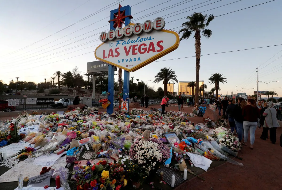 The "Welcome to Las Vegas" sign is surrounded by flowers and items, left after the October 1 mass shooting, in Las Vegas, Nev., on Oct. 9, 2017. (Las Vegas Sun/Steve Marcus)