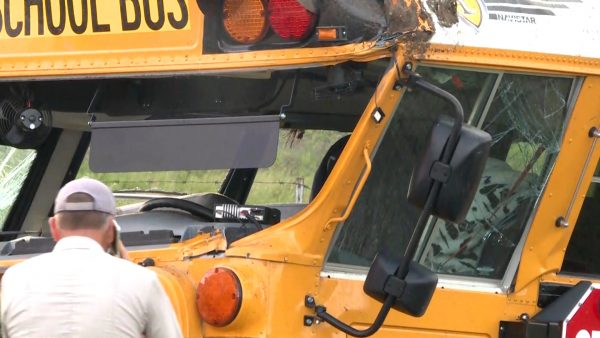 A man inspects the damaged bus