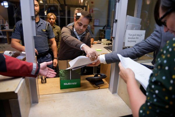 An employee hands out the court findings at the district court in Stockholm
