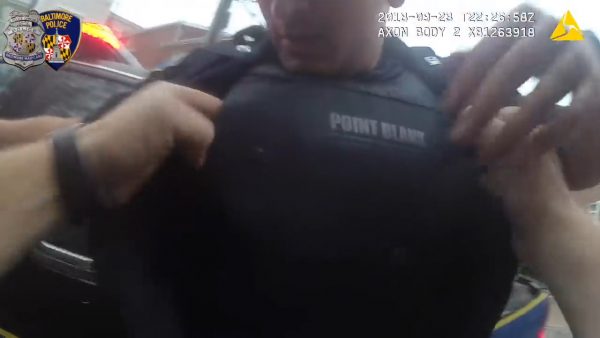 one police officer examines another for wounds