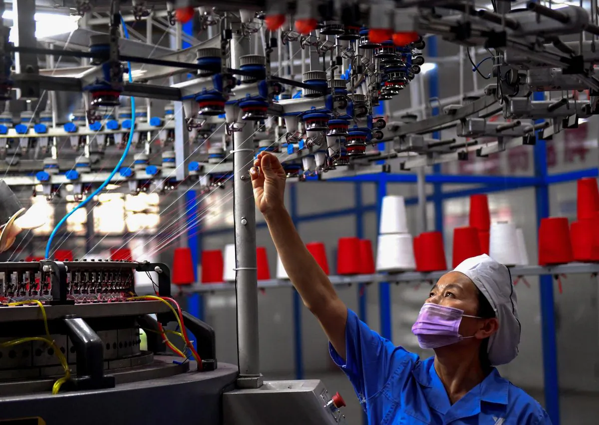 An employee monitors a circular weaving machine at a textile factory in Shangqiu City, Henan Province, China, on Sept. 8, 2018. (STR/AFP/Getty Images)