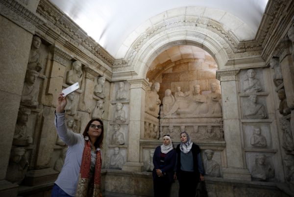 A visitor uses her mobile phone to take a selfie during the reopening of Syria's National Museum of Damascus