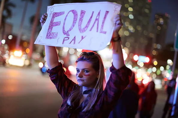 Clarissa Horsfall holds a sign reading, 'Equal Pay,' as she joins with others during 'A Day Without A Woman' demonstration on March 8, 2017 in Miami, FL. (Joe Raedle/Getty Images)