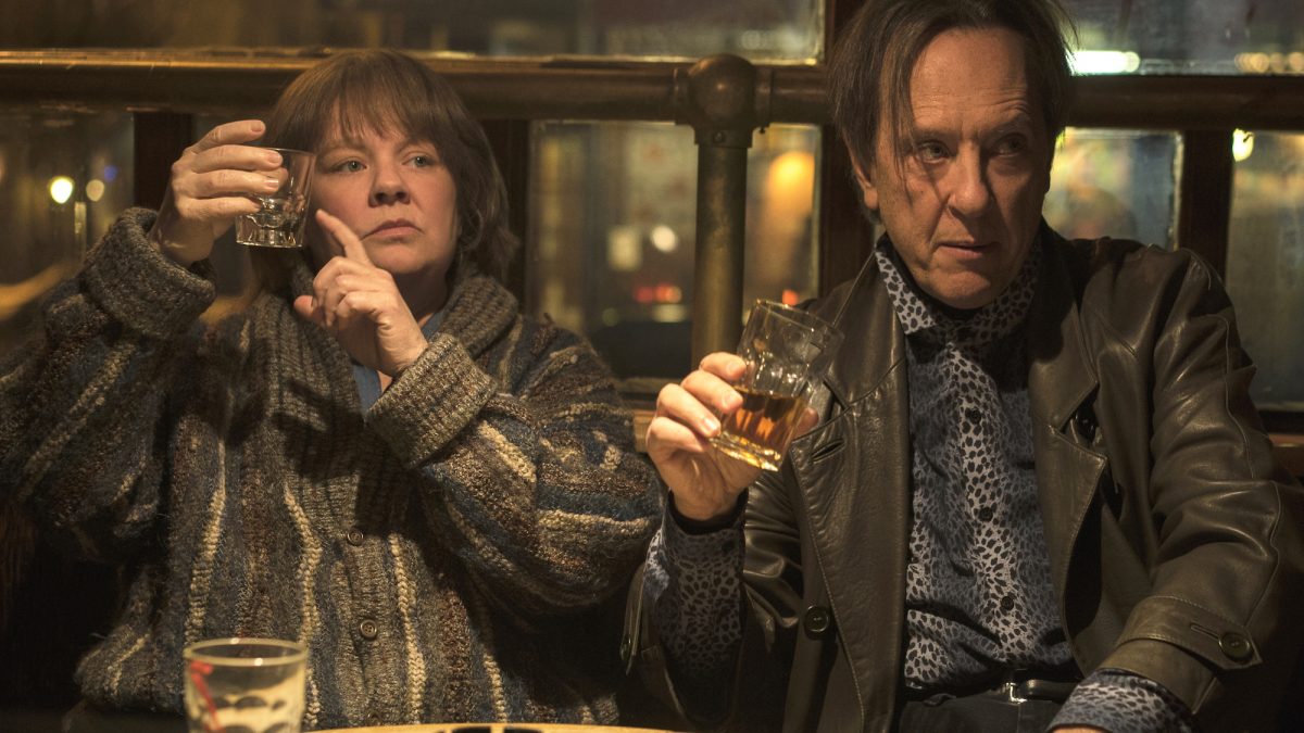 Melissa McCarthy and Richard E. Grant drink in a bar