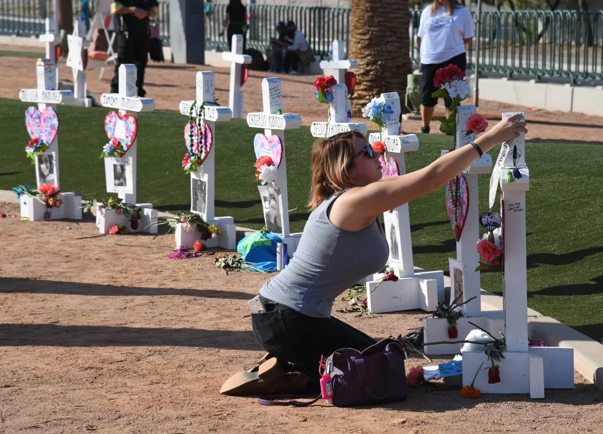 Ashley Schuck of Nevada places a medal she got for running for shooting victim Neysa Tonks in Saturday's Vegas Strong 5K on a cross set up for Tonks in Las Vegas, Nevada, on Oct. 1, 2018. (Ethan Miller/Getty Images)