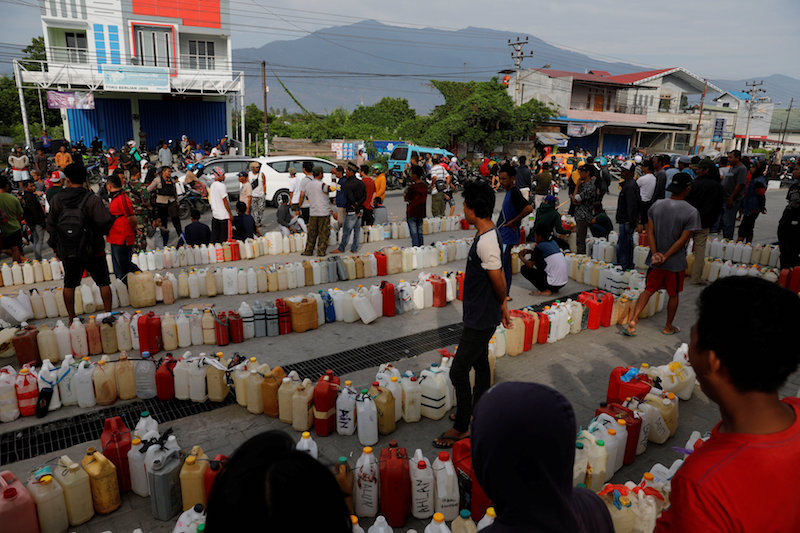 people wait to buy fuel in Palu