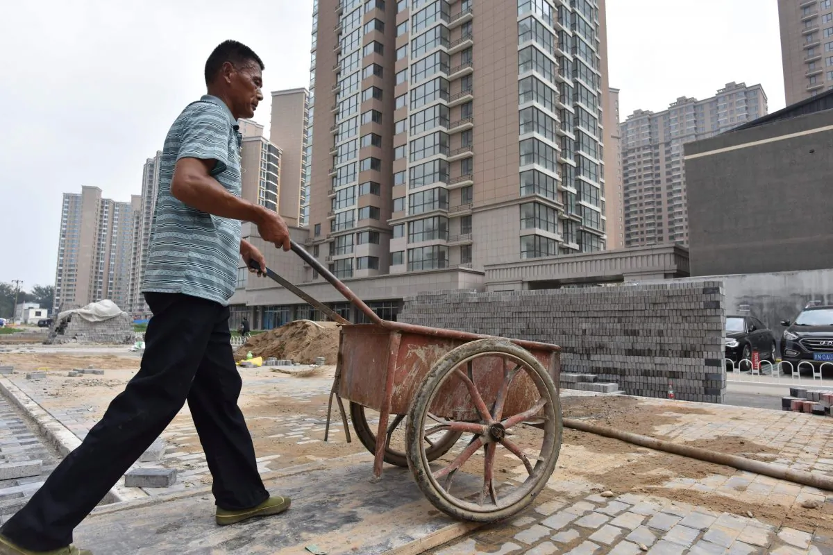 A worker pushes cart at the construction site of a housing complex under construction in Beijing on Aug. 15, 2017. (Greg Baker/AFP/Getty Images)