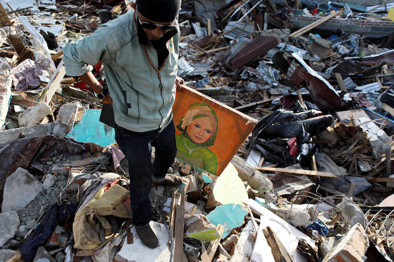 child carries mothers picture after earthquake