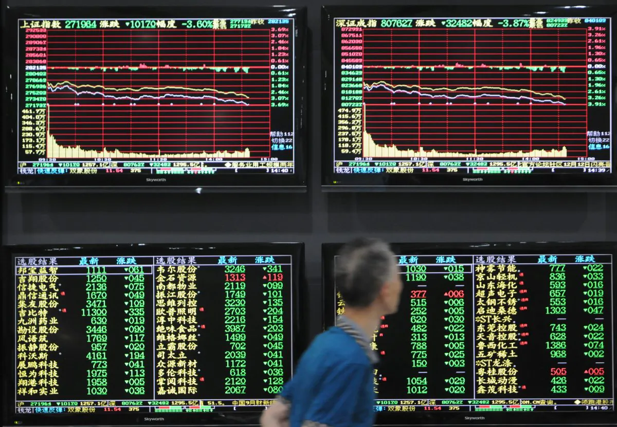 A man walks past screens showing stock information at a brokerage house in Jiujiang, Jiangxi Province, China on Oct. 8, 2018.  (Stringer/Reuters) 
