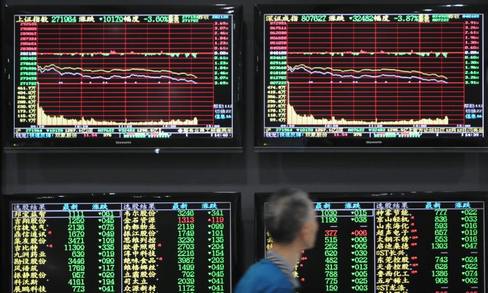 A man walks past screens showing stock information at a brokerage house in Jiujiang, Jiangxi Province, China on Oct. 8, 2018.  (Stringer/Reuters) 