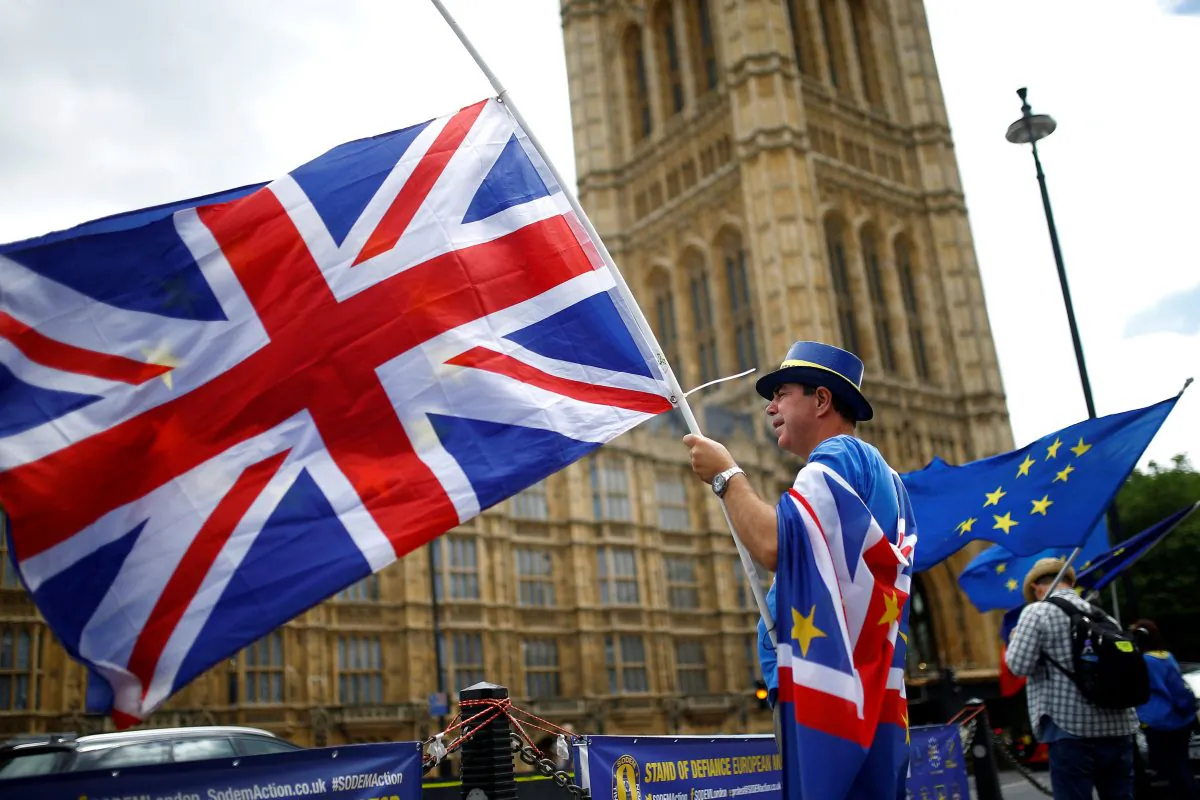 Anti-Brexit demonstrators wave EU and Union flags opposite the Houses of Parliament, in London on June 19, 2018. (Henry Nicholls/Reuters)