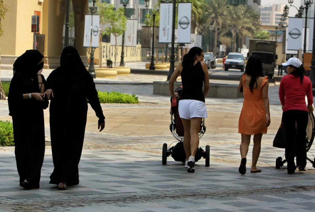 Foreign women walk past fully-veiled local women in Dubai in this file photo. (Karim Sahib/AFP/Getty Images)