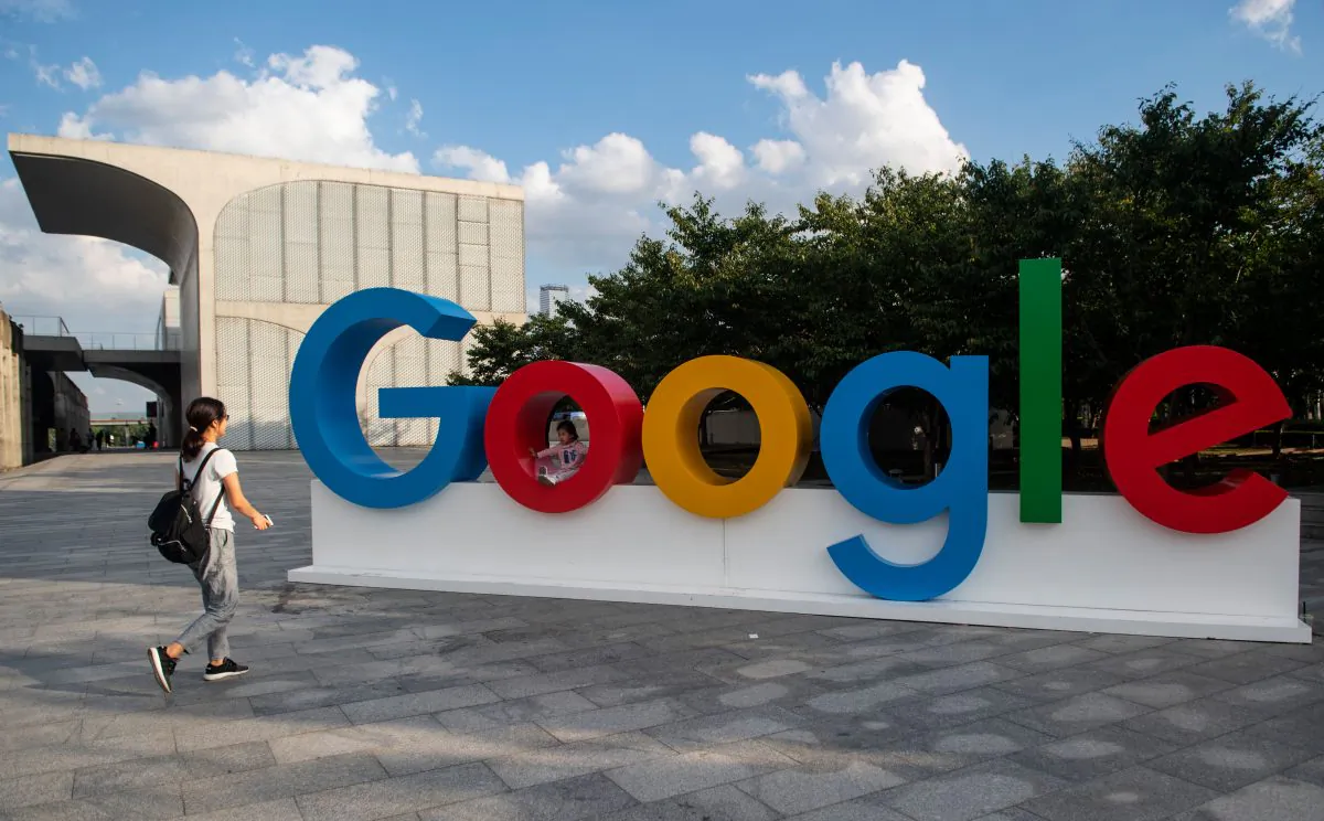 A woman and her child play on a Google sign in Shanghai on Sept. 26, 2018. (Johannes Eisele/AFP via Getty Images)