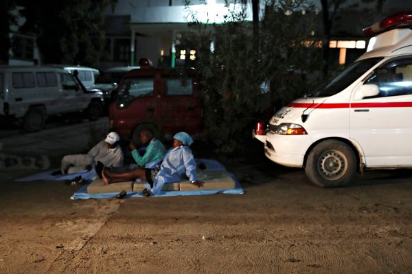 Hospital workers rest outside hospital