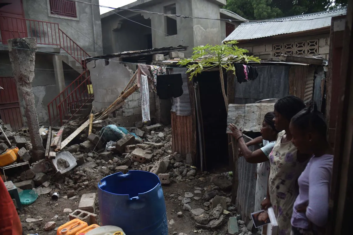 A faimily looks at the rubbles of their destroyed house in Gros Morne, Haiti, on Oct. 8, 2018. - A 5.9-magnitude earthquake that struck off the northwest coast of Haiti during the weekend of October 6, 2018, has killed at least 15 people, authorities said on October 8, increasing the previous toll by three.  HECTOR RETAMAL/AFP/Getty Images)