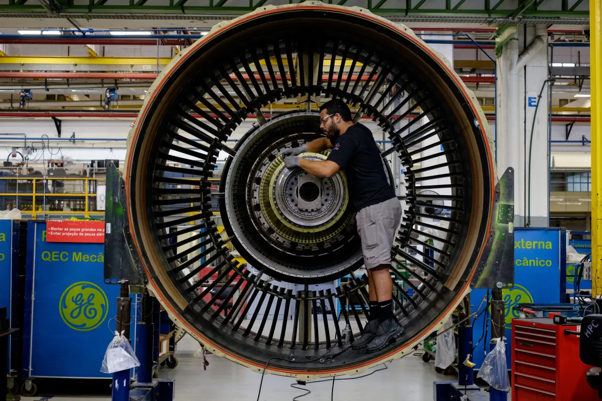 A man works with a jet engine at General Electric's aviation engine overhaul facility in Petropolis, Rio de Janeiro, Brazil on June 8, 2016. (YASUYOSHI CHIBA/AFP/Getty Images)