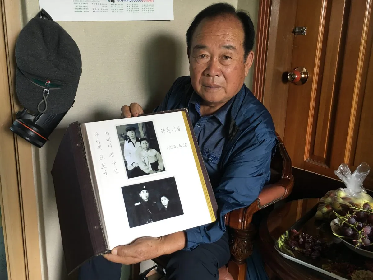 Koh Ho-jun shows photos of the engagement of his brother, Koh Ho-seok, to his wife in North Korea which Koh Ho-jun received during an inter-Korean family reunion, in his home in Cheongju, South Korea, on Oct. 2, 2018. (Seungmock Oh/Special to The Epoch Times)