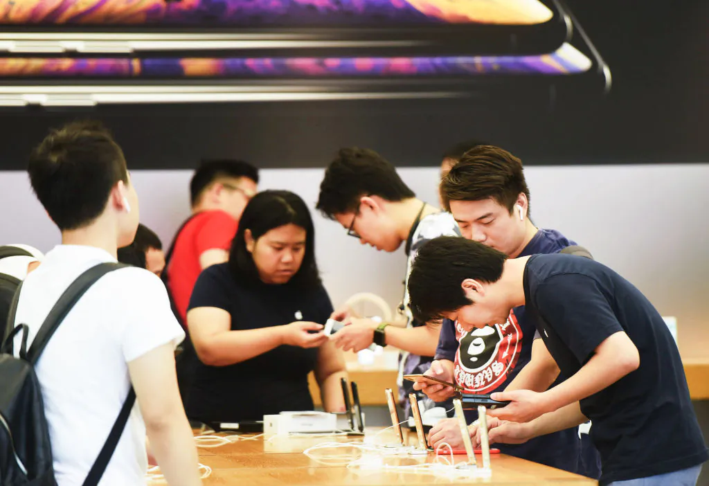 Customers look at the iPhone XS and XS Max models at an Apple store in Hangzhou in China's eastern Zhejiang Province on Sept. 21, 2018. (STR/AFP/Getty Images)