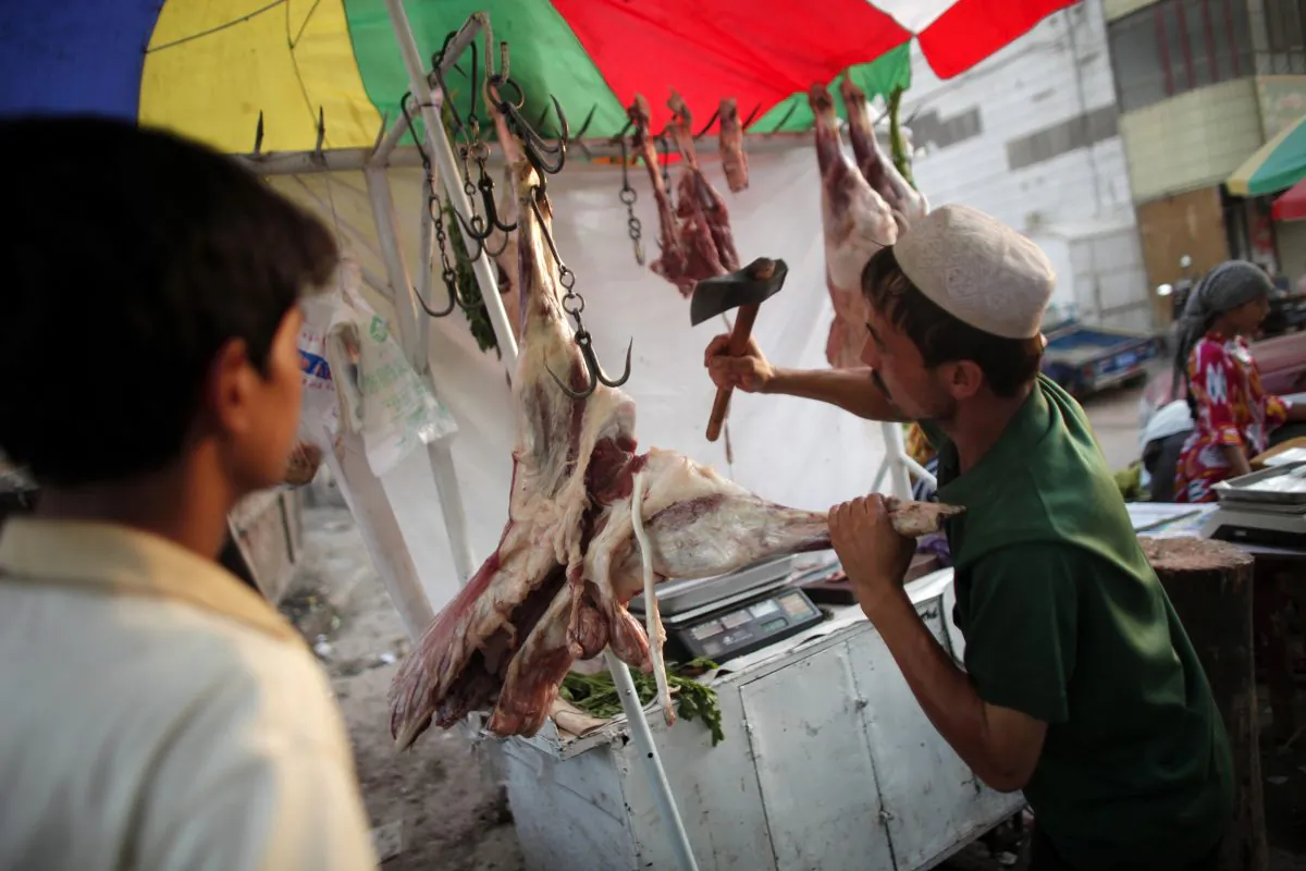 An Uyghur vendor cuts meat at a street market in Kashgar, Xinjiang region, China on Aug. 3, 2011. (Carlos Barria/Reuters)