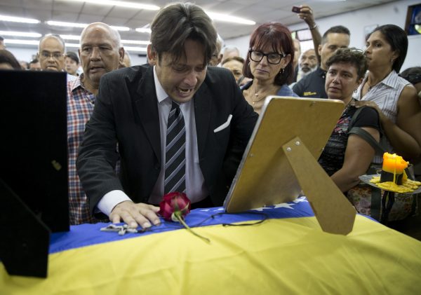 man mourns casket remains Fernando Alban