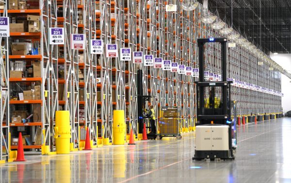 A worker drives a Powered Industrial Truck at the Amazon fullfillment center in Aurora