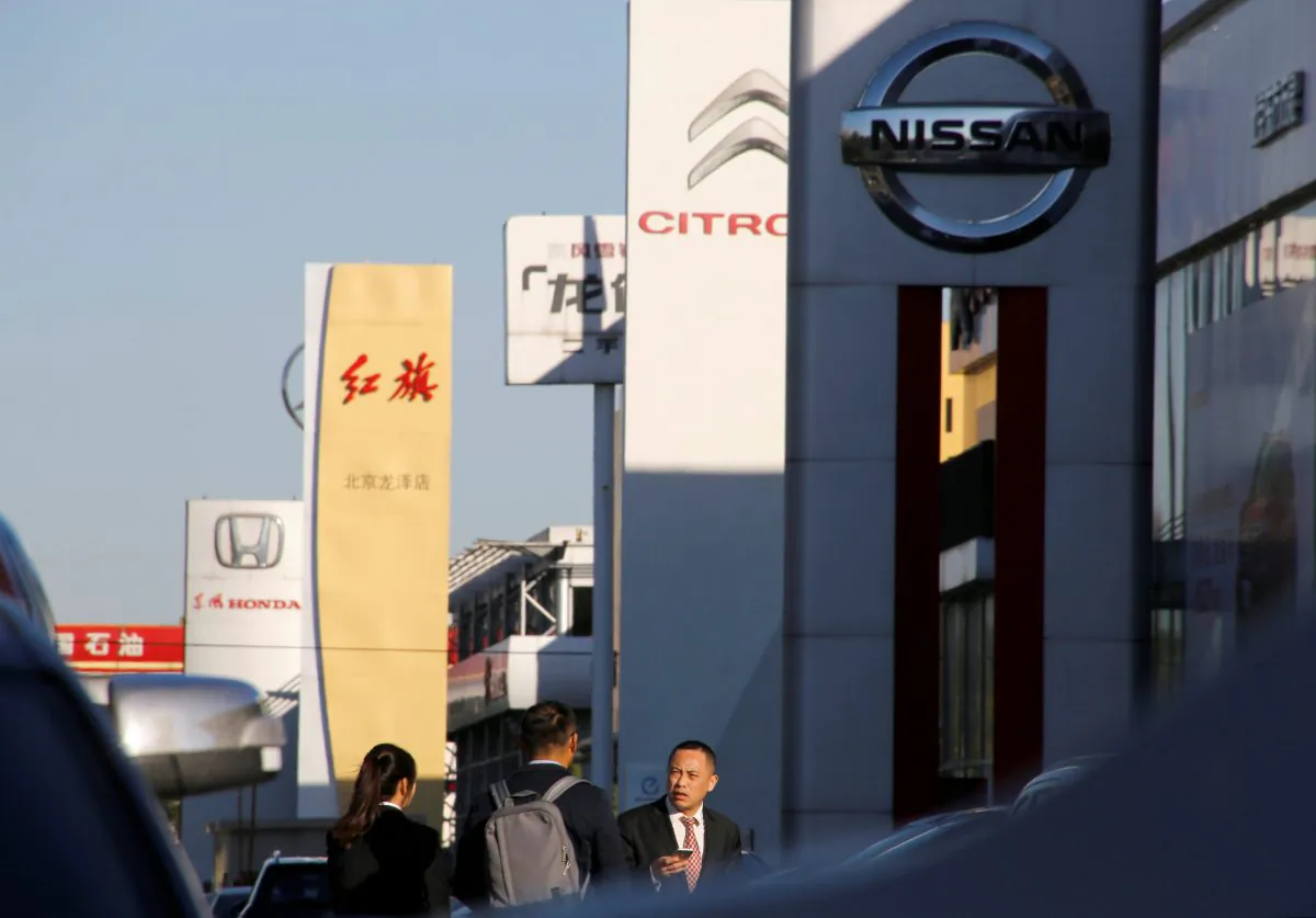People walk near the showrooms of Chinese and foreign car dealerships in Beijing on Oct. 11, 2018.  (Thomas Peter/Reuters)