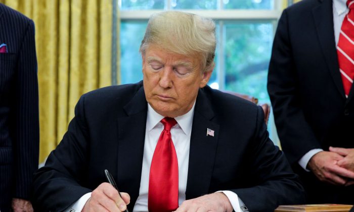 President Donald Trump signs S. 3508, the Save Our Seas Act of 2018, during a ceremony in the Oval Office of the White House on Oct. 11, 2018. (Oliver Contreras -Pool/Getty Images)