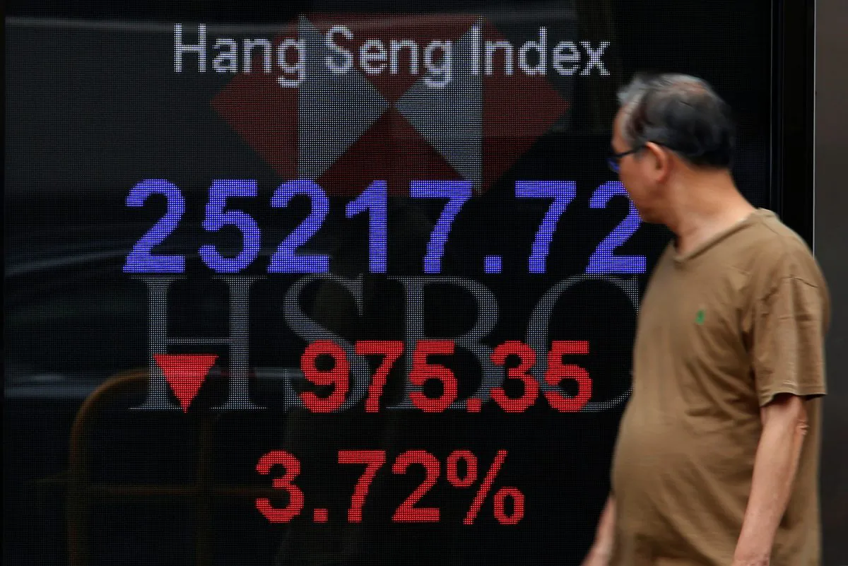 A man walks past a panel displaying the Hang Seng Index during morning trading in Hong Kong, on Oct. 11, 2018.  (Bobby Yip/Reuters)