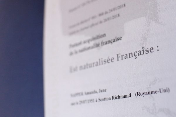 Words "Naturalized French" are seen on a French naturalization document