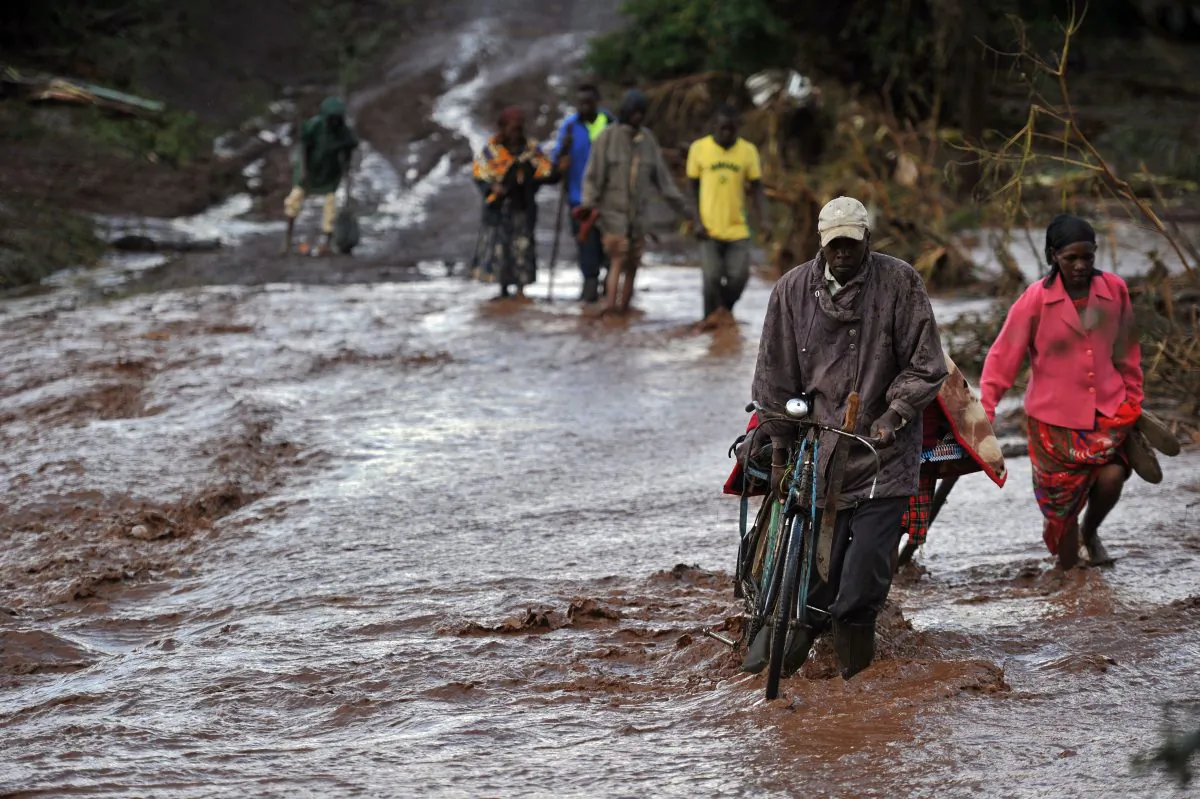 Villagers cross through receding waters in an area of flash flooding at Solai in Subukia, Nakuru County, Kenya, on May 10, 2018. (Tony Karumba/AFP/Getty Images)