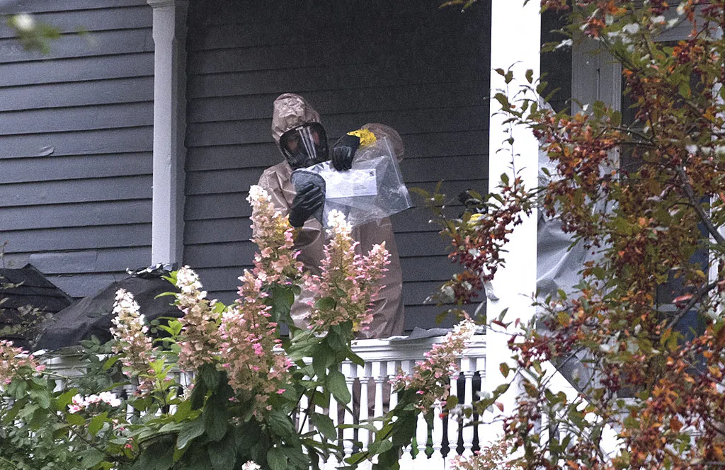 A person in a hazmat suit appears to be handling a letter that is enclosed in a plastic bag at the home of Sen. Susain Collins in Bangor, Maine, Monday, Oct. 15, 2018. (Gabor Degre/The Bangor Daily News via AP)