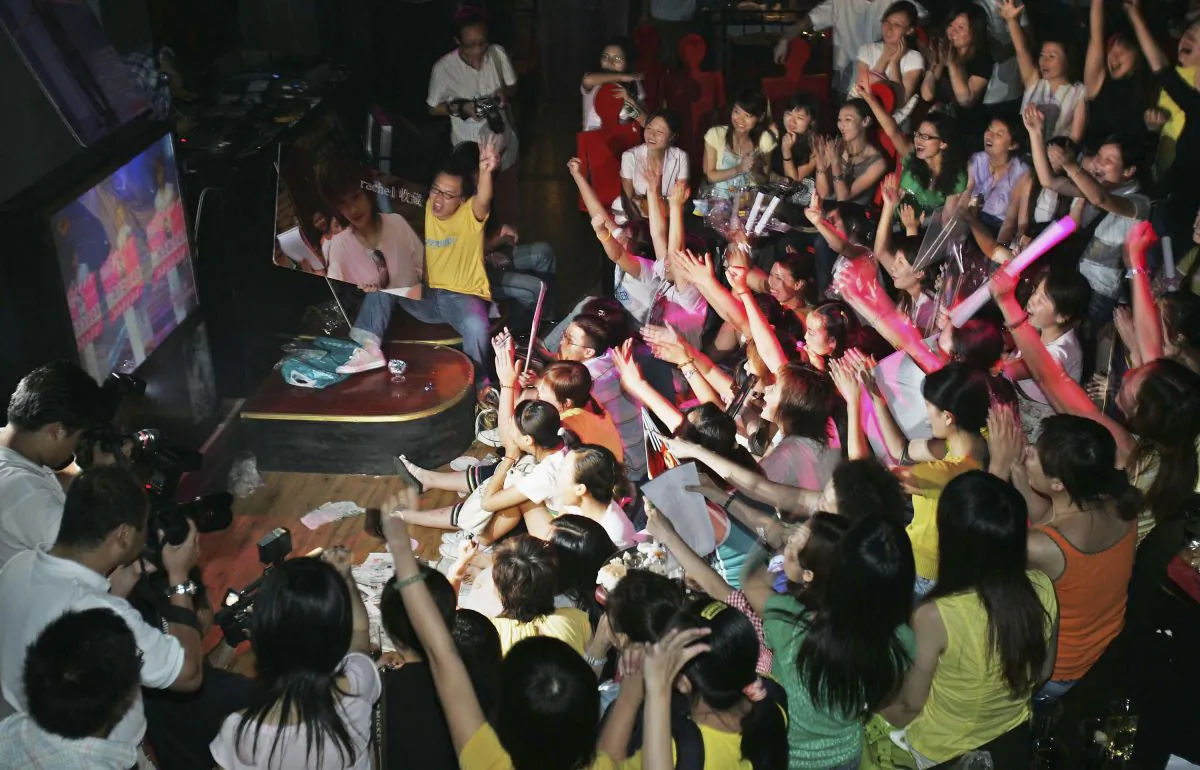 Fans of the TV Show "Super Girl Voice" watch and cheer for their favorite contestants at a bar on Aug. 26, 2005 in Shanghai, China. (China Photos/Getty Images)
