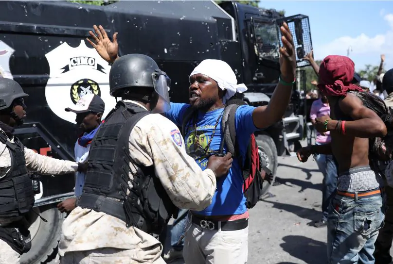 A Haitian National Police officer pushes a protester during a march on Oct. 17, 2018. (Andres Martinez Casares/Reuters)